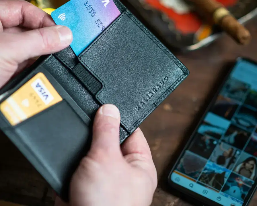 person holding wallet with credit cards